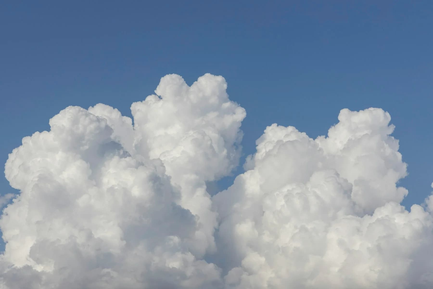 Sunlit clouds opening into a blue sky